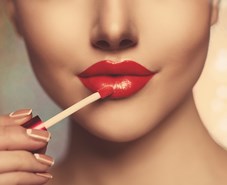 Model applying red lipstick